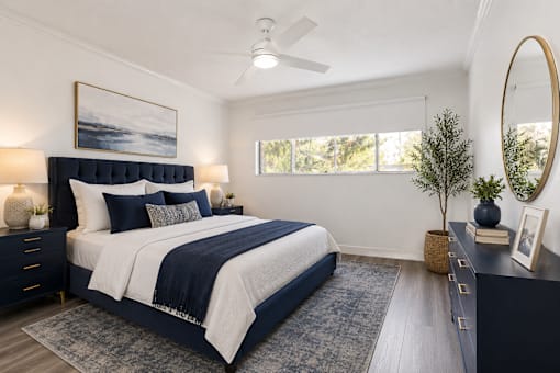 A bedroom with a large bed and a ceiling fan.
