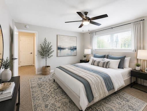 A bedroom with a large bed and a ceiling fan.