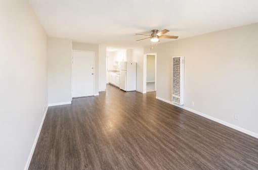 A room with wooden flooring and a ceiling fan.