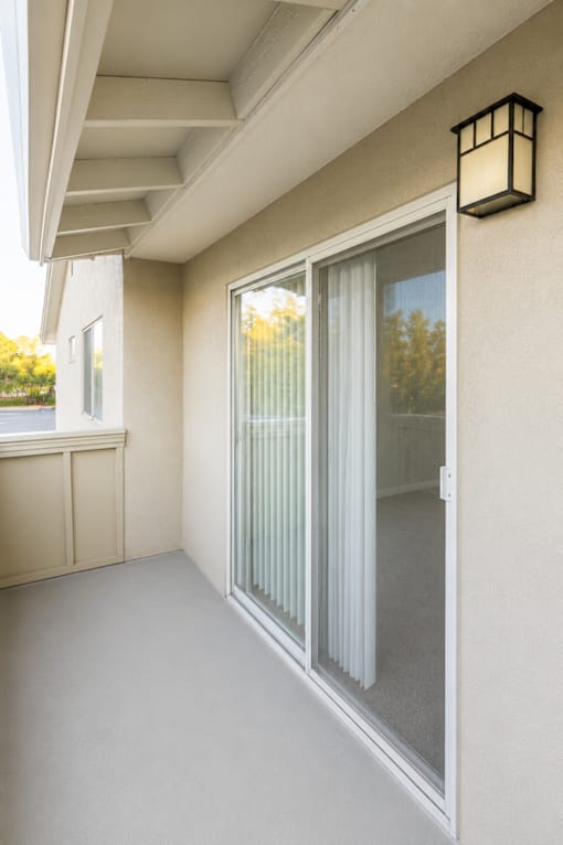 A white sliding door with a glass panel and a black lantern on the wall.