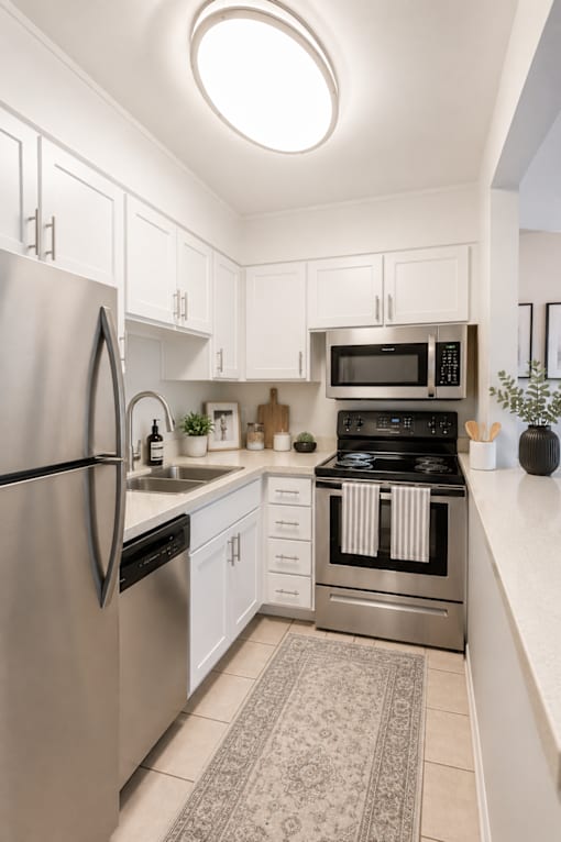 A modern kitchen with a refrigerator, microwave, and oven.