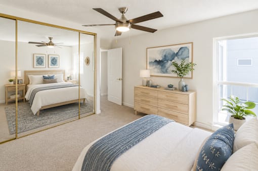 A bedroom with a large bed and a ceiling fan.