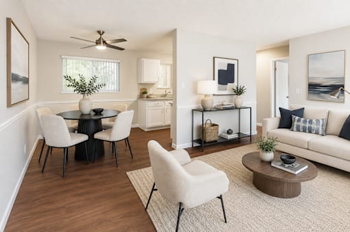 A living room with a white couch, a black table, and a ceiling fan.
