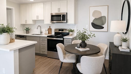 A modern kitchen with a dining table set for two.