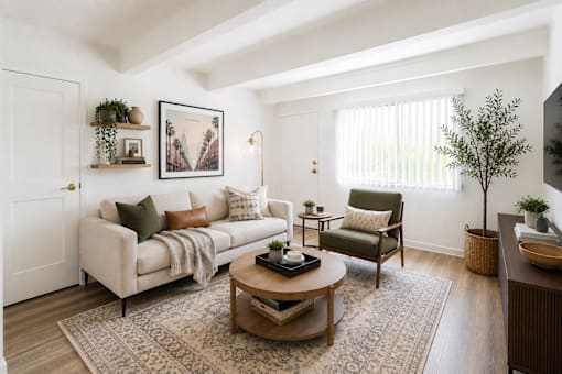 A living room with a white couch, a green armchair, and a coffee table.