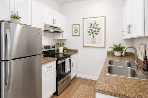A modern kitchen with a stainless steel refrigerator and a sink.