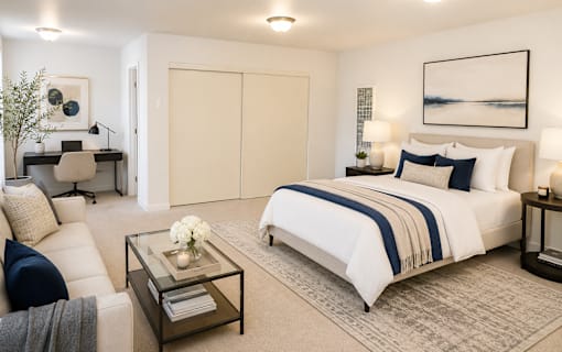 A bedroom with a large bed and a couch.