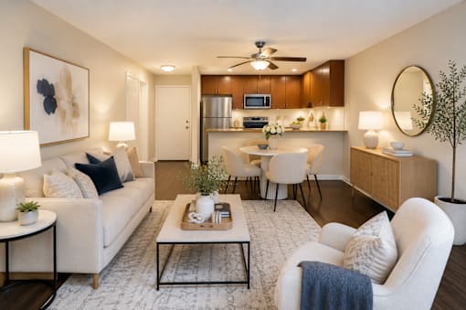 A modern living room with a white sofa, a coffee table, and a ceiling fan.