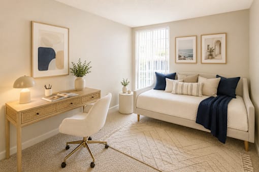 A well-lit room with a bed, desk, and chair.