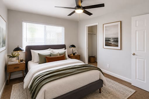 A bedroom with a large bed and a ceiling fan.