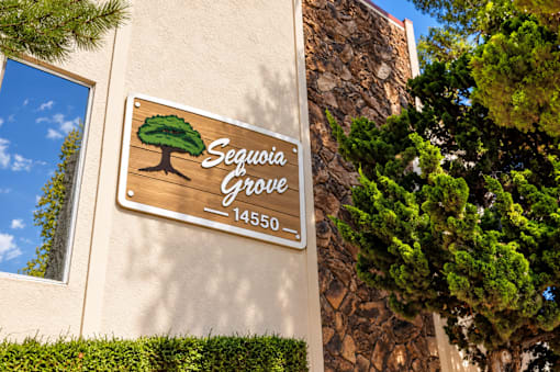 A sign for Sequoia Grove is mounted on a wall.