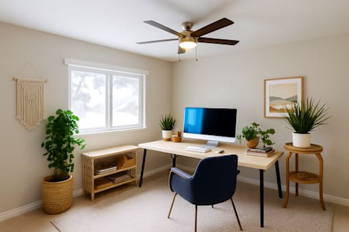 A room with a desk, chair, and a fan.