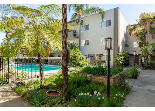 an apartment building with a swimming pool and palm trees