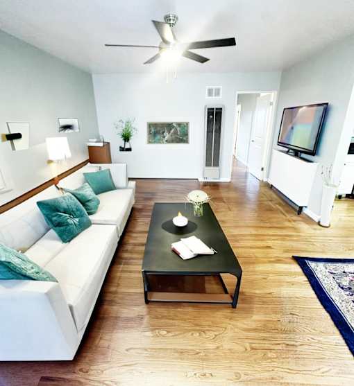 A living room with a white couch and a black coffee table.