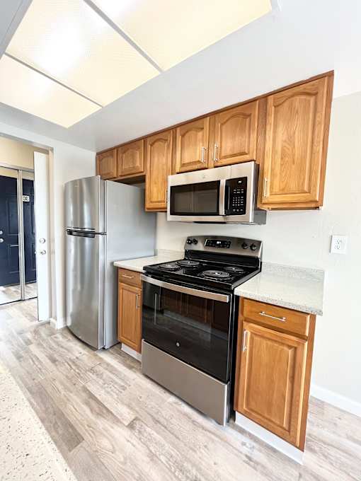 A kitchen with a stove, oven, microwave, and refrigerator.
