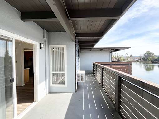 A balcony with a view of a lake.