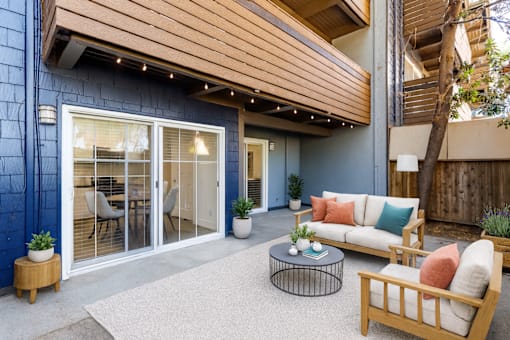 A modern outdoor living space with a sofa, chairs, and a coffee table.