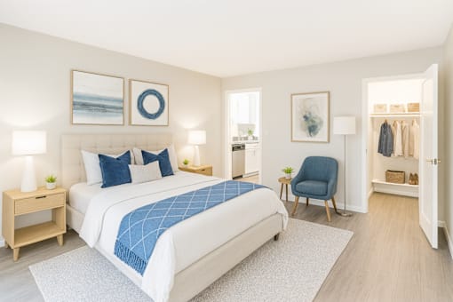 A bedroom with a large bed and a blue chair.