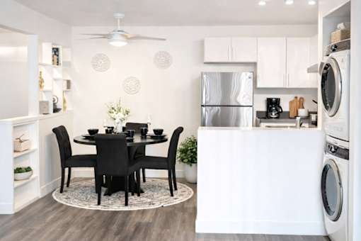 A modern kitchen with a dining table set for four.