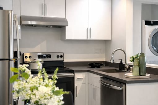 A modern kitchen with a stainless steel refrigerator and a black oven.