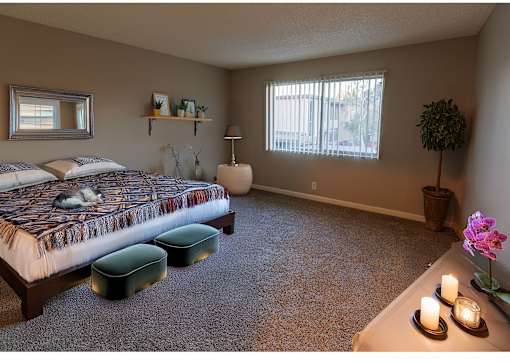 a bedroom with a bed and a table with a cat on it