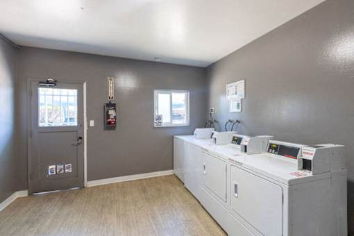 A room with a grey door and a white machine with a monitor on it.