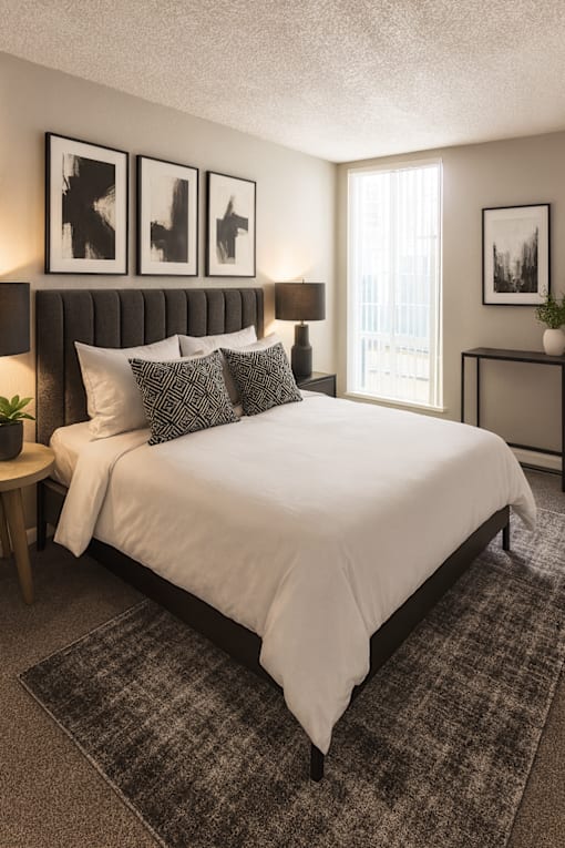 A bedroom with a large bed and a window.