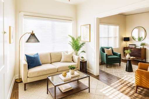 A living room with a white sofa, a green armchair, a coffee table, and a lamp.