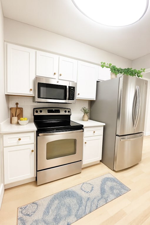 A kitchen with a stove, oven, microwave, and refrigerator.