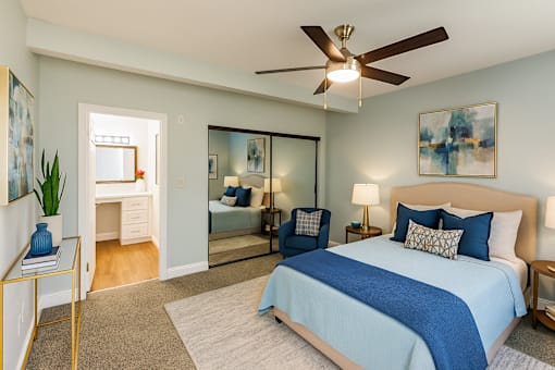 A bedroom with a large bed and a ceiling fan.