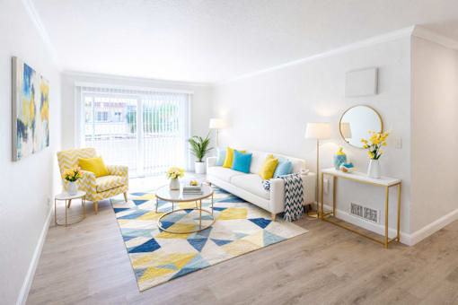 A living room with a yellow chair and a white couch.