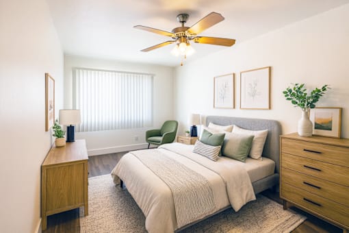 A bedroom with a bed, nightstand, and chair.