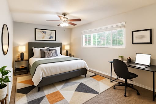 A bedroom with a bed, desk, and chair.