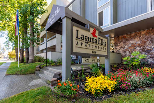 A sign for Laguna Ellis Apartments is displayed in front of a building.