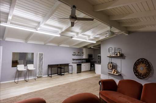 a living room with a ceiling fan and a kitchen