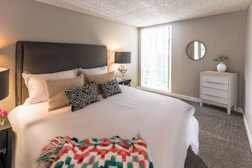 A bedroom with a large bed and a nightstand.