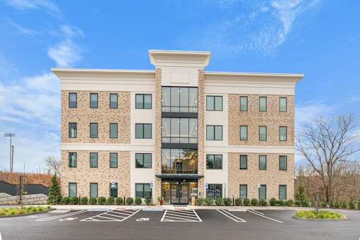 A large building with a parking lot in front.