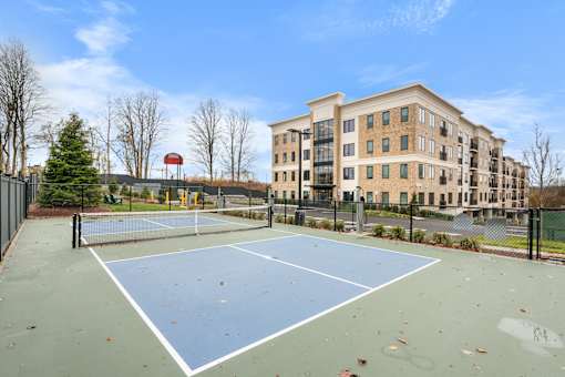 A pickleball sport court in front of an apartment building.