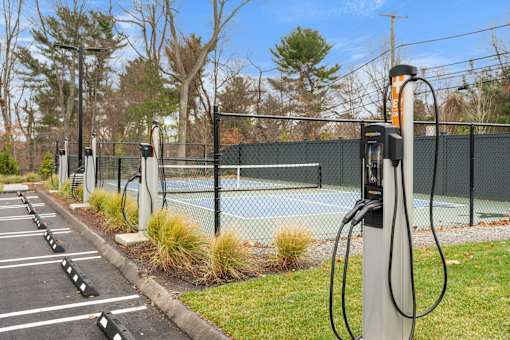 A row of electric vehicle charging stations are lined up in a parking lot.