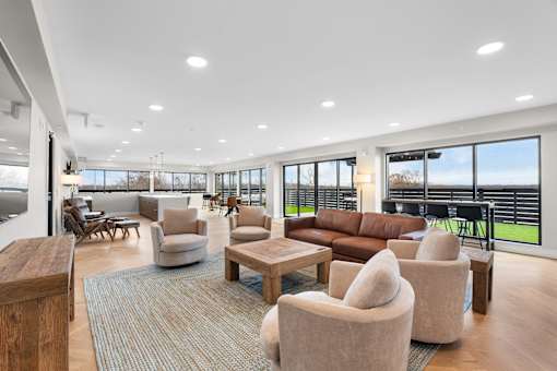 A spacious rooftop lounge with a variety of seating options and a view of the outdoors.