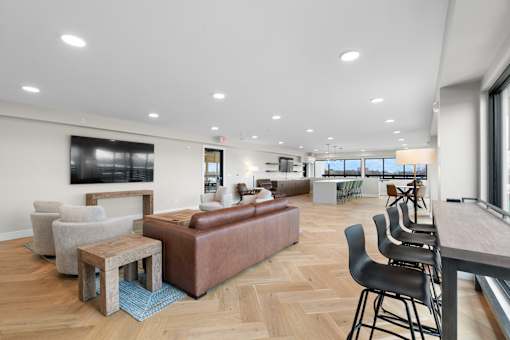 A modern living room with a brown leather couch and a wooden coffee table.