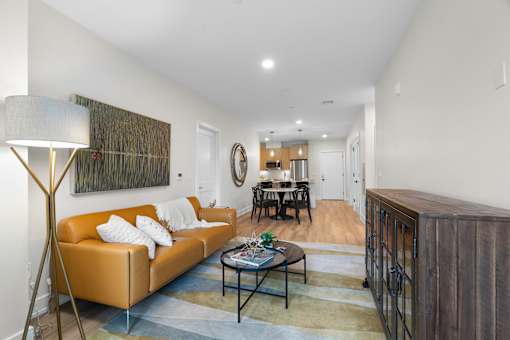 A living room with a yellow couch and a coffee table.