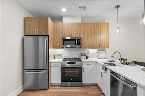 A modern kitchen with wooden cabinets and stainless steel appliances.