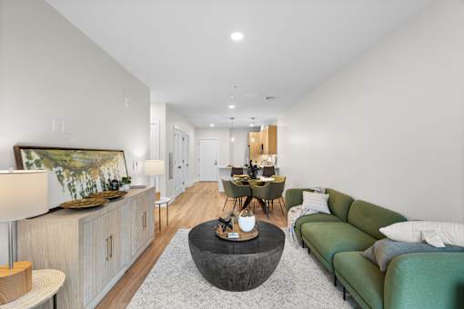 A modern living room with a green sofa and a wooden coffee table.