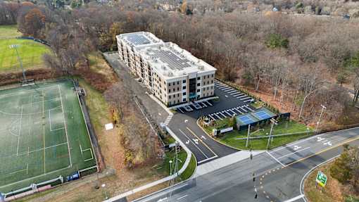 A large building with a tennis court in front of it.