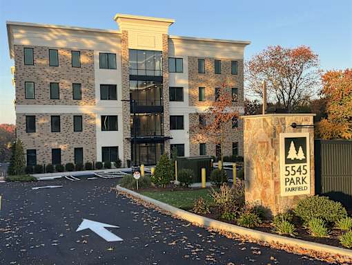 an apartment building with a sign for sss park entrance