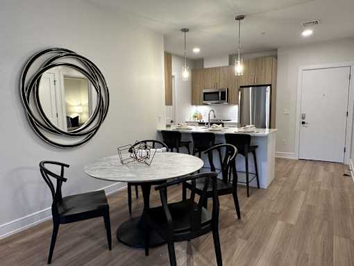 An apartment kitchen with a round table and chairs.