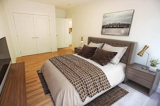 A bedroom with a large bed and a painting on the wall.