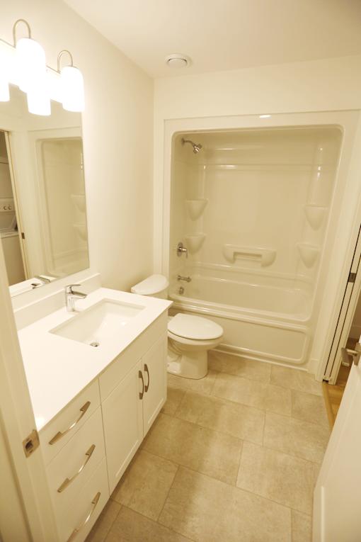A white bathroom with a sink, toilet and bathtub.