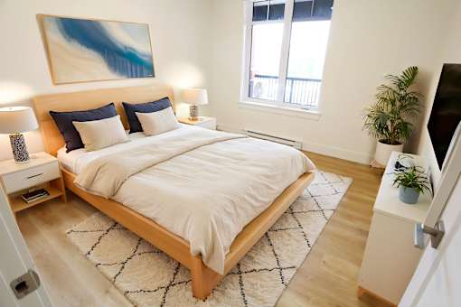 A bedroom with a large bed and a painting on the wall.
